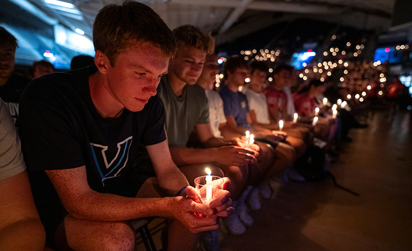 Students at a candle lighting ceremony during orientation.