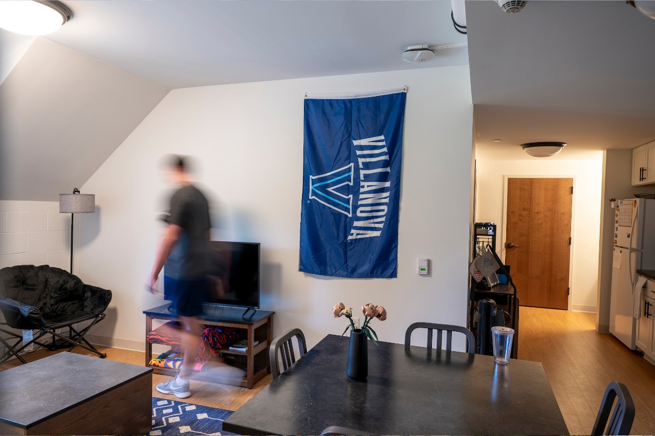 Students walking through a residence hall room