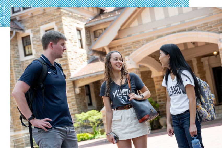 Three students chatting in front of Montefalco Hall at Cabrini Campus