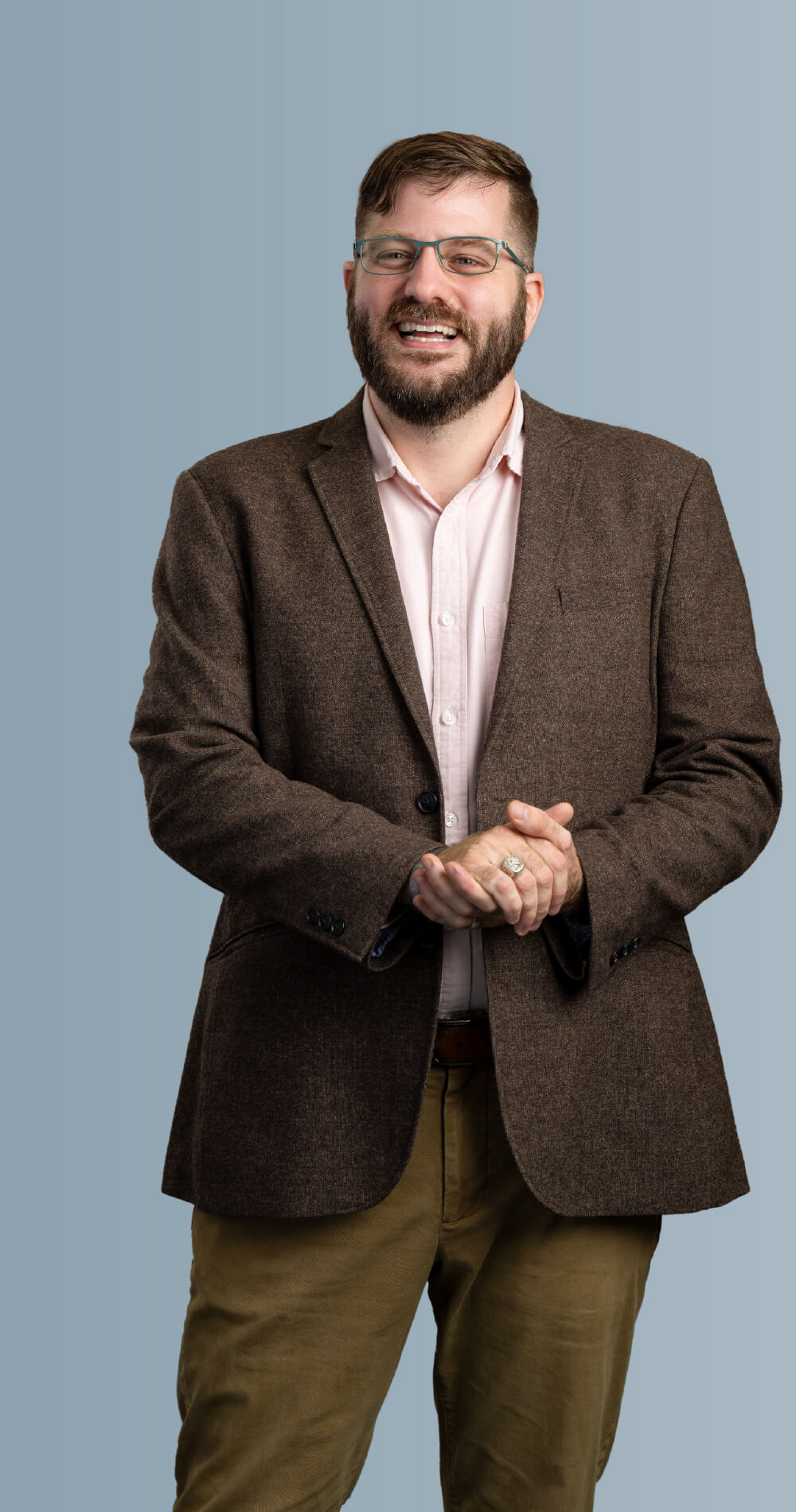 Guy Mattingly Weissinger II, selected as a Villanova Change-Maker, stands smiling with his hands held together. He wears glasses and appears confident and approachable.