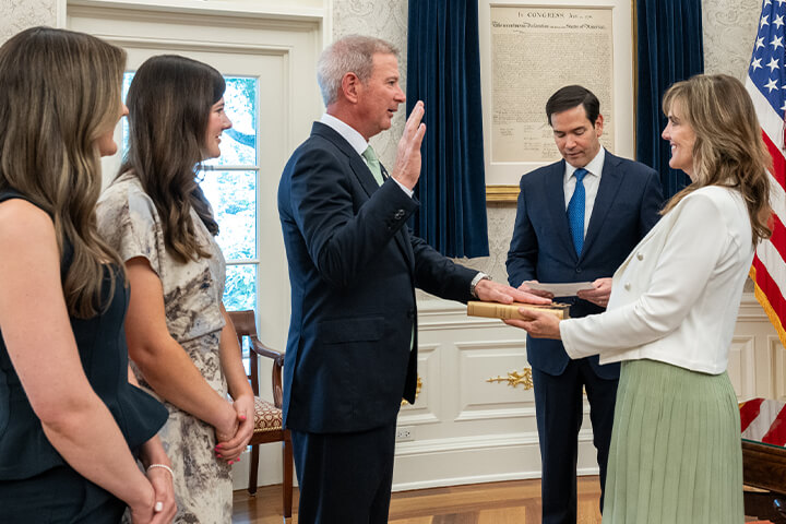 Edward Walsh is sworn in as US Ambassador to Ireland by Secretary of State Marco Rubio in the Oval Office; his wife, Lynn, holds the Bible, and two daughters stand nearby.