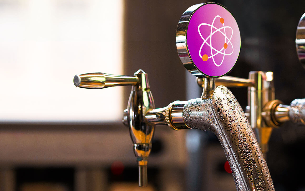 A beer tap featuring an atomic symbol, blending themes of science and brewing.