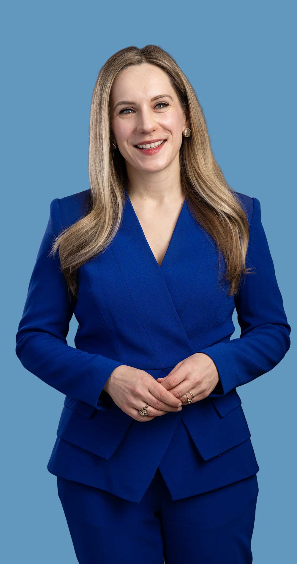 Catherine Stecyk poses for a portrait against a blue background.